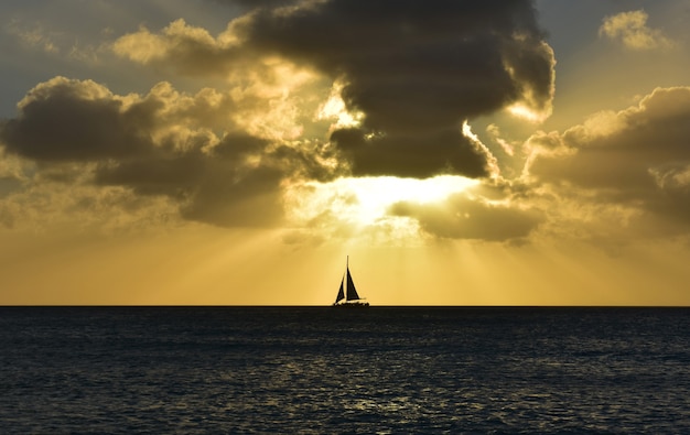 Splendida barca a vela sotto un tumultuoso cielo arancione ad Aruba.