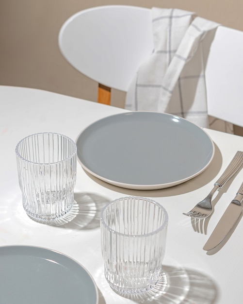 Splendida cornice: piatti e bicchieri vuoti sul tavolo. Luce solare intensa