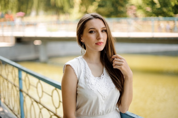 Splendida donna con i capelli scuri in elegante abito bianco