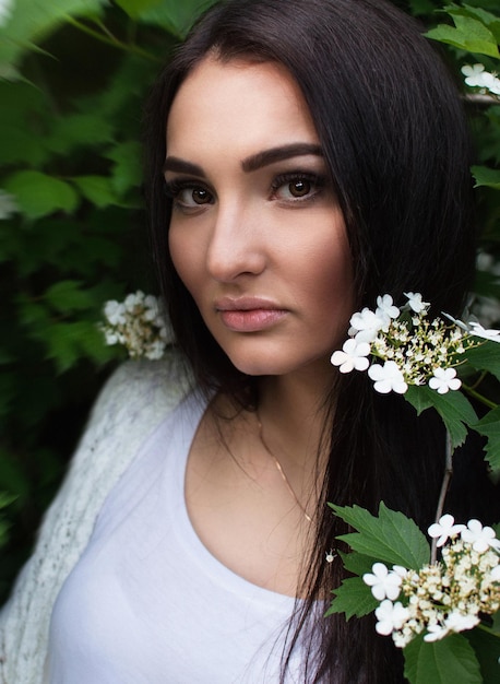 Splendida giovane bella ragazza nell'erba nel parco Donna con un bel trucco in una giacca leggera che riposa in un parco Sogno Erbe curative