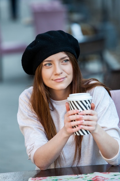 Splendida giovane donna con una tazza di caffè in città street city