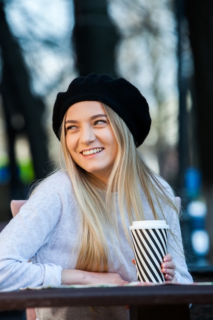 Splendida giovane donna con una tazza di caffè in città street city