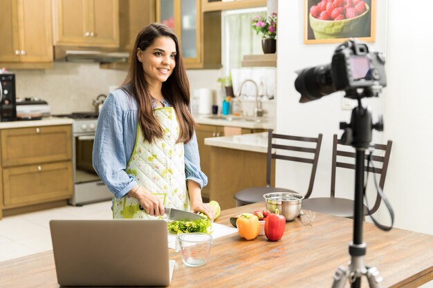 Splendida giovane donna ispanica che registra un video per il suo blog di cucina in una cucina