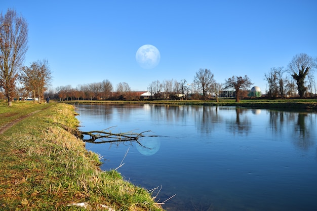 splendida luna piena nella campagna riflessa sul fiume