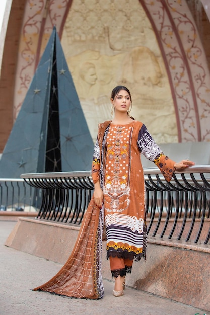 Splendida ragazza Desi che indossa un abito tradizionale marrone per un servizio fotografico di moda al monumento in Pakistan