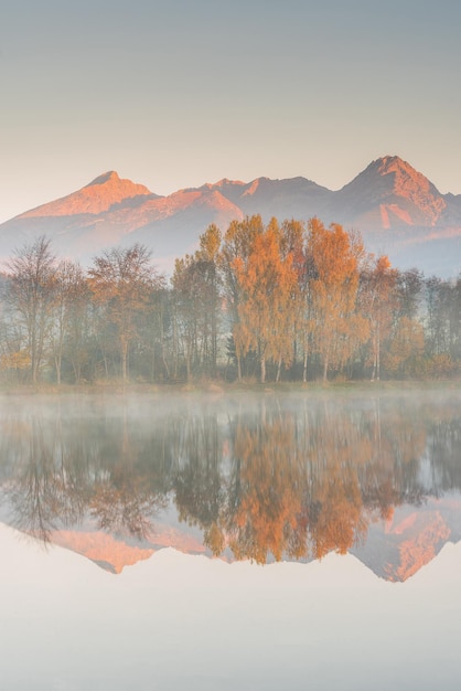 Splendida riflessione di picco nel lago e nel fogliame autunnale