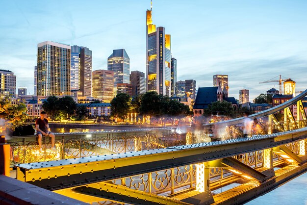 Splendida vista del paesaggio urbano sui grattacieli illuminati e sul ponte durante il crepuscolo a Francoforte, Germania