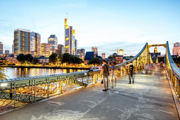 Splendida vista del paesaggio urbano sui grattacieli illuminati e sul ponte durante il crepuscolo a Francoforte, Germania