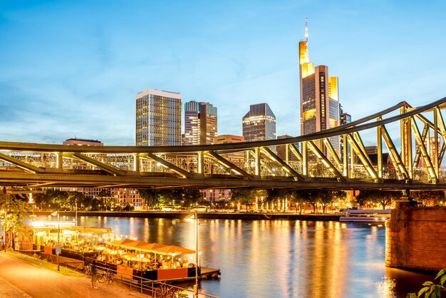 Splendida vista del paesaggio urbano sui grattacieli illuminati e sul ponte durante il crepuscolo a Francoforte, Germania