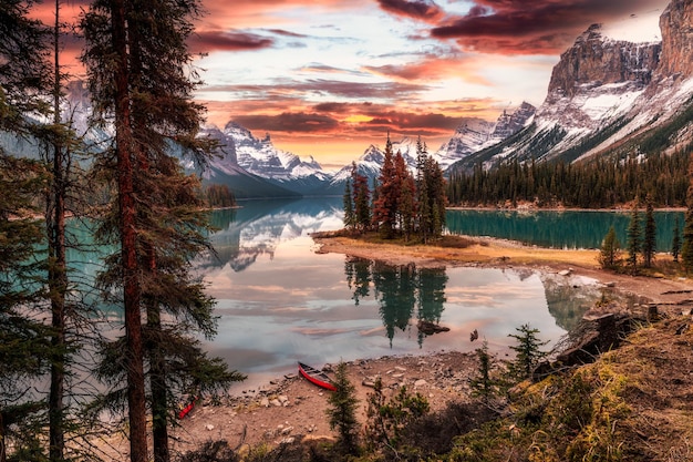 Splendida vista dell'isola di Spirit con canoa e cielo drammatico nella stagione autunnale al tramonto al parco nazionale Jasper AB Canada