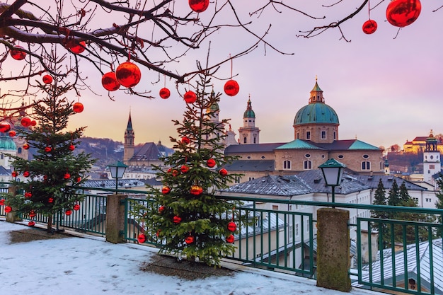 Splendida vista della storica città di Salisburgo con la famosa Cattedrale di Salisburgo in inverno, Austria. Alberi di Natale con palle di Natale rosse contro la città di Salisburgo.