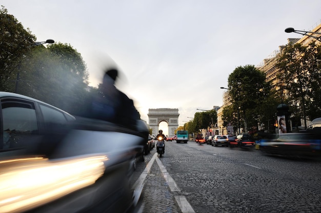 Splendida vista notturna con traffico automobilistico e corsa alla sera dell'Arco di Trionfo, Parigi, Francia.