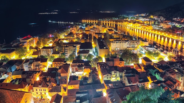 Splendida vista panoramica aerea del fiume e delle montagne della città vecchia di Omis Cetina di notte