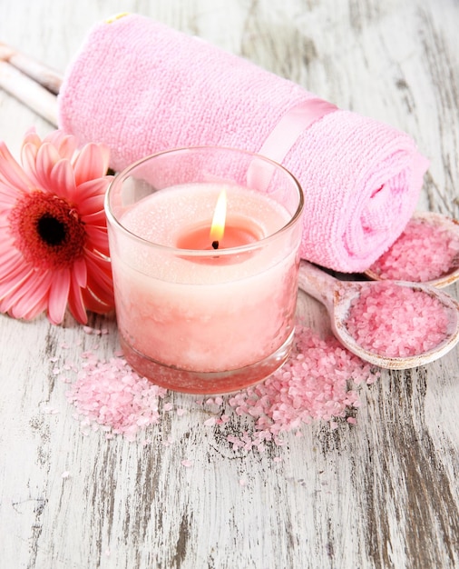 Splendido ambiente termale con candela rosa e fiore su sfondo di legno