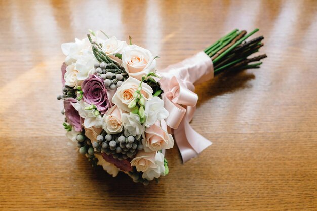 Splendido bouquet da sposa su uno sfondo di legno Il bagliore della luce solare cade