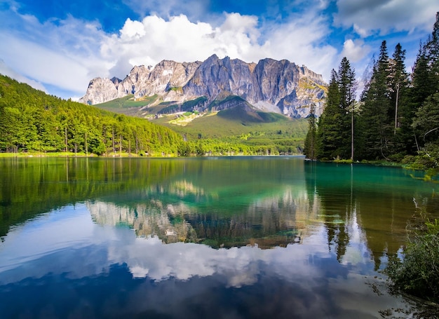 Splendido paesaggio con un lago in una foresta e un'alta montagna rocciosa incredibile