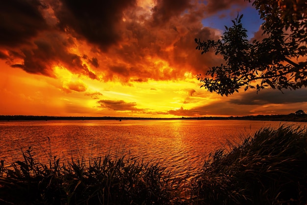 Splendido tramonto sul lago con drammatiche nuvole arancioni