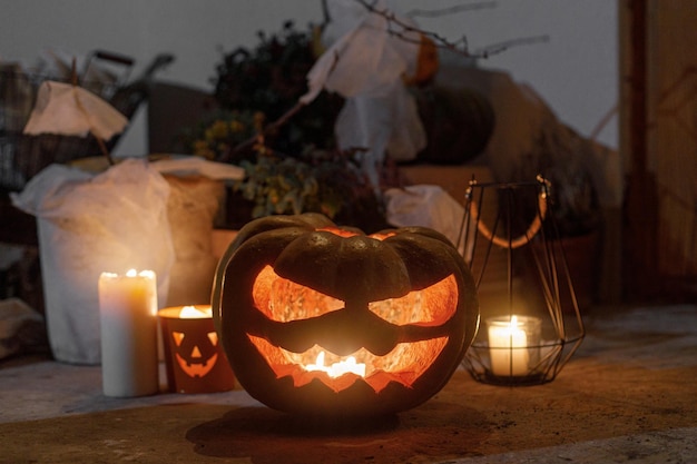 Spooky Jack o lantern ragni zucca e candele accese nel buio portico di Halloween e decorazioni d'ingresso Spaventose decorazioni di Halloween fuori casa Dolcetto o scherzetto