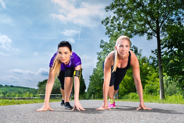 Sport all'aperto - giovani donne che fanno forma fisica nel parco