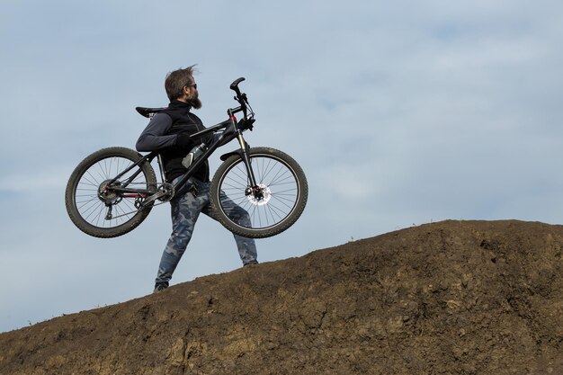 Sport brutale ragazzo barbuto su una moderna mountain bike Bella vista dalla montagna Vista panoramica per banner