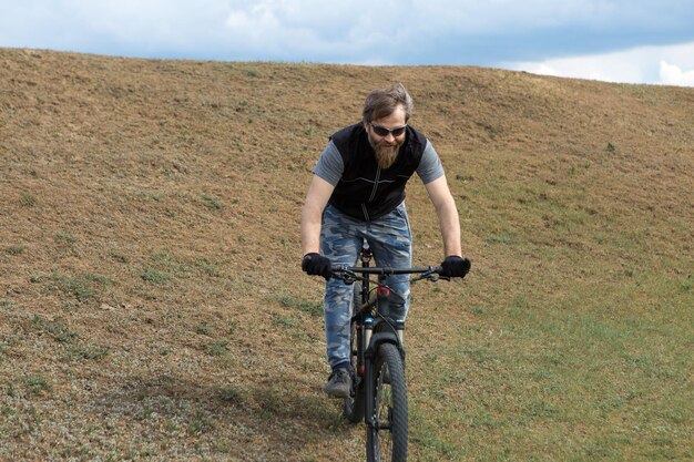 Sport brutale ragazzo barbuto su una moderna mountain bike Un ciclista in un luogo deserto di sale in riva al lago