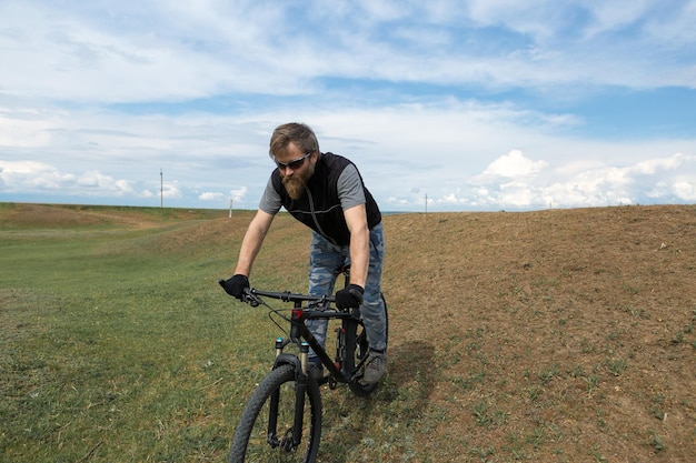 Sport brutale ragazzo barbuto su una moderna mountain bike Un ciclista in un luogo deserto di sale in riva al lago