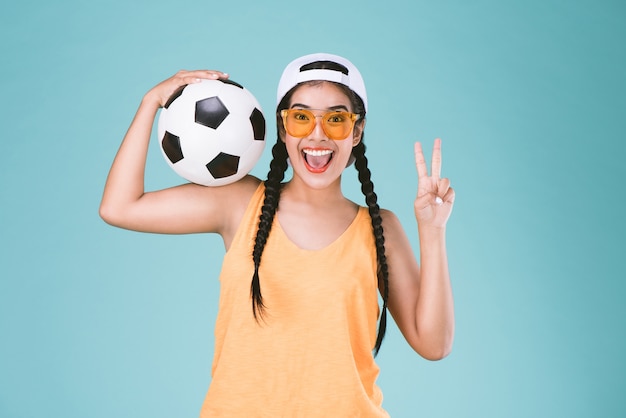 sport donna Fan in possesso di un pallone da calcio, celebrando il punto due dita fino secondo segno