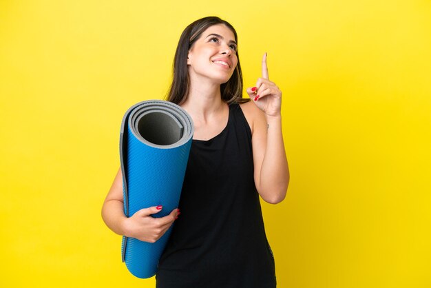 sport Donna italiana che va a lezioni di yoga isolata su sfondo giallo che indica una grande idea