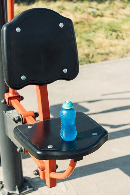 Sport e concetto di fitness. Allenarsi sul campo sportivo bevendo acqua dal thermos.