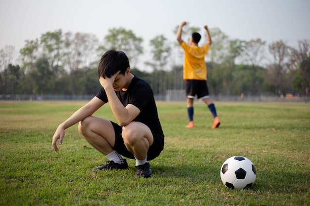 Sport e ricreazione un momento di vittoria e sconfitta di due giocatori dopo la partita di calcio.