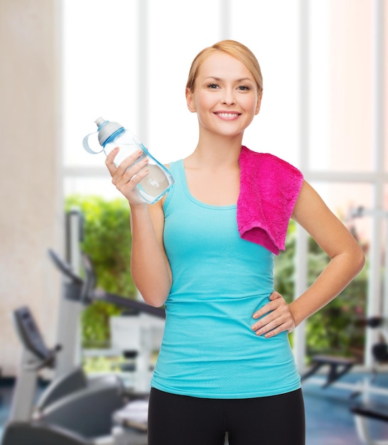 sport, esercizio e assistenza sanitaria - donna sportiva con asciugamano rosa e bottiglia d'acqua
