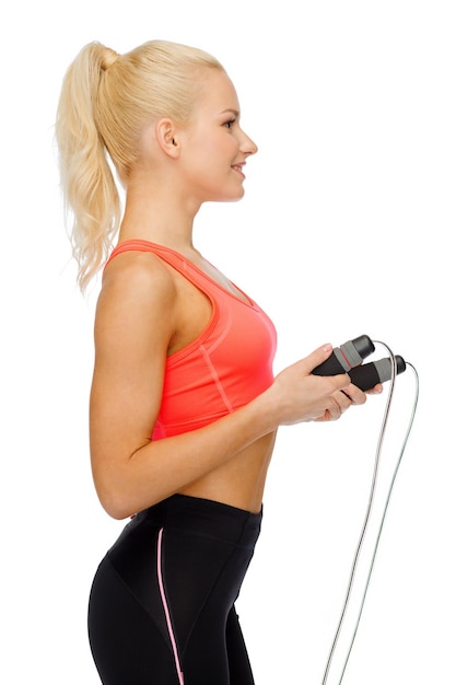 sport, esercizio fisico e assistenza sanitaria - donna sportiva sorridente con la corda per saltare