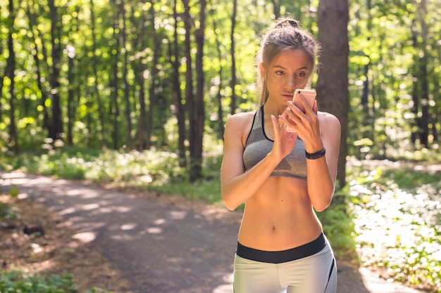 Sport, fitness, tecnologia e persone concetto giovane donna atleta