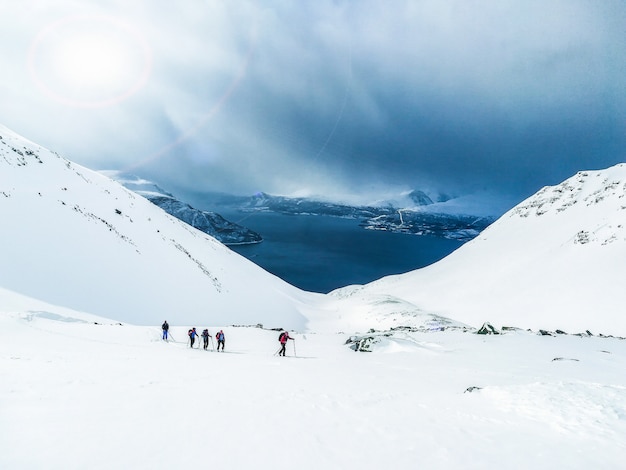 Sport invernali, gruppo che cammina nella neve, scialpinismo, fiordo della Norvegia