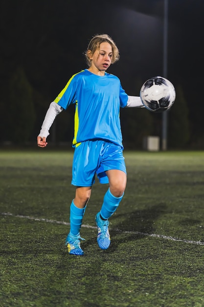 Sport per bambini e calcio con una giocatrice di calcio su un campo all'aperto per esercizio fisico o