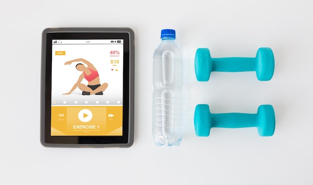 sport, stile di vita sano, fitness, tecnologia e concetto di oggetti - primo piano del computer tablet pc con manubri e bottiglia d'acqua su sfondo bianco