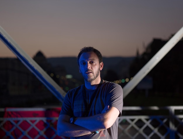 sport urbani, giovane uomo sano che fa jogging attraverso il ponte della città al mattino presto di notte