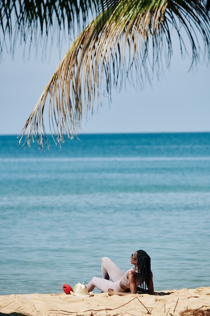 Sportiva che riposa sulla spiaggia