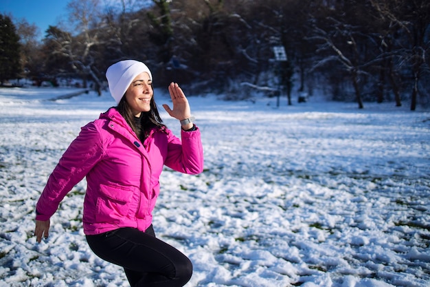 Sportiva in abbigliamento invernale allenamento sulla neve.