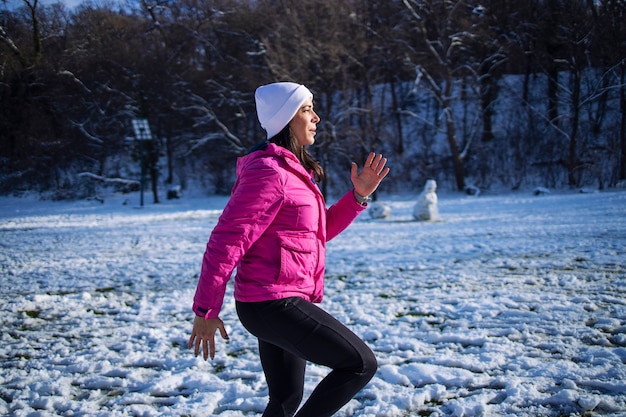 Sportiva in abbigliamento invernale allenamento sulla neve.