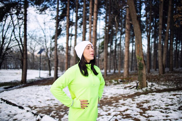 Sportiva in abiti da allenamento invernale per iniziare a correre sulla neve.