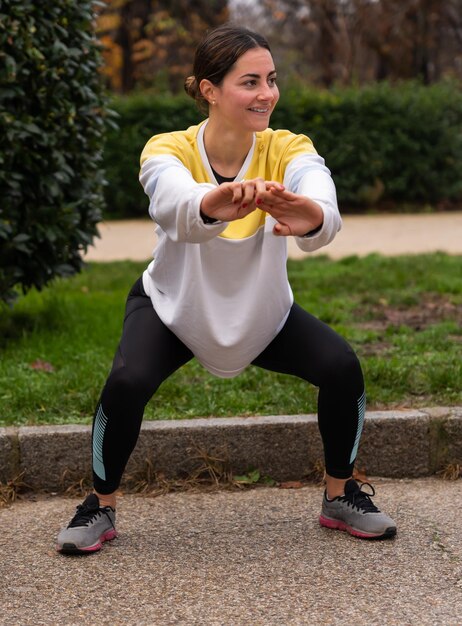 Sportiva sorridente che si esercita nel parco