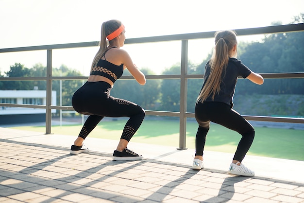 Sportive belle sorelle anziane e più giovani che si riuniscono insieme durante l'allenamento fitness all'aperto.