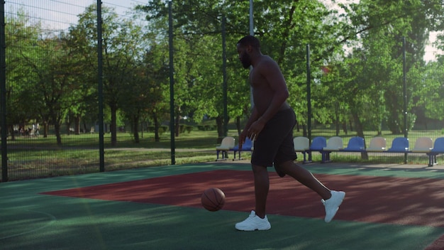Sportivo afroamericano che si allena da solo nel parco giochi con corpo nudo