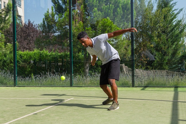 Sportivo afroamericano nero che gioca a paddle tennis