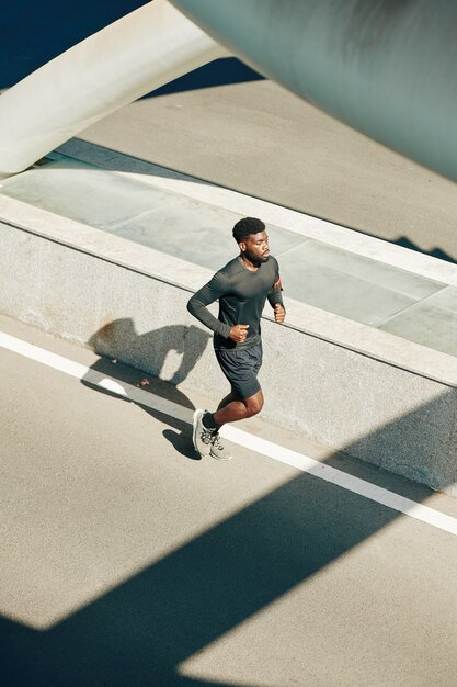 Sportivo che corre lungo la strada