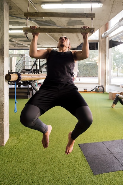 Sportivo che fa pull up in palestra