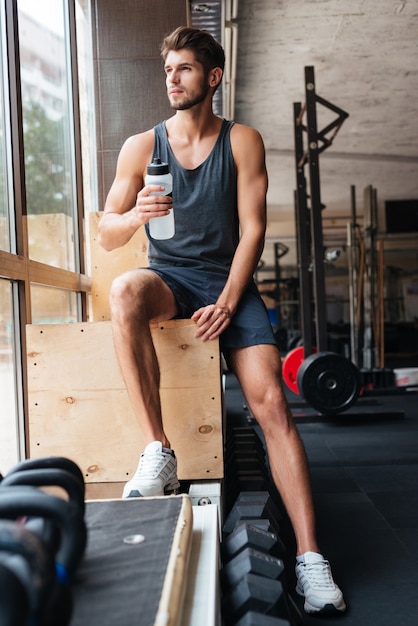 Sportivo di moda in palestra. con bottiglia