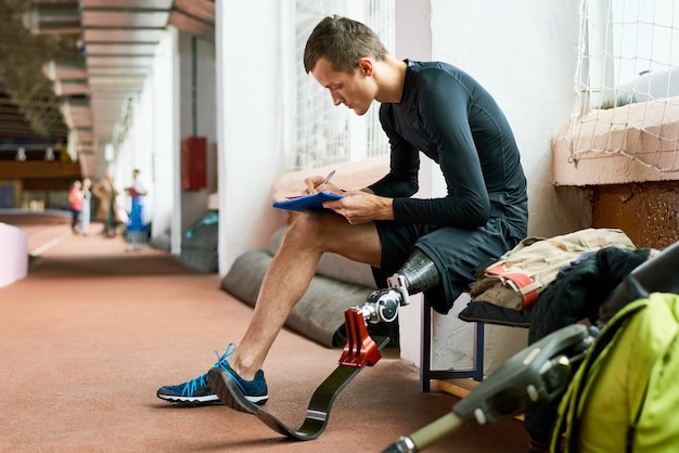 Sportivo disabile che si siede sul banco