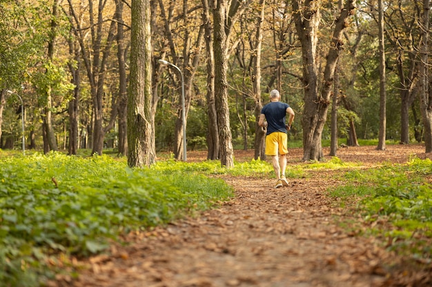 Sportivo maturo che fa allenamento cardio nella foresta